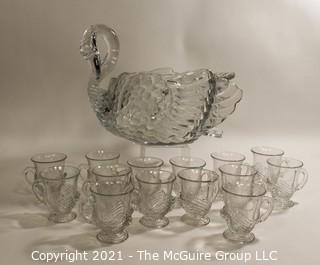 Unmarked Clear Cambridge Glass Swan Punch Bowl with 12 Swan Cups & Ladle. It measures approximately 15 long, 10" tall and 10" wide.  Chip in back tail feather. 