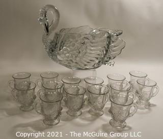 Unmarked Clear Cambridge Glass Swan Punch Bowl with 12 Swan Cups & Ladle. It measures approximately 15 long, 10" tall and 10" wide.  Chip in back tail feather. 