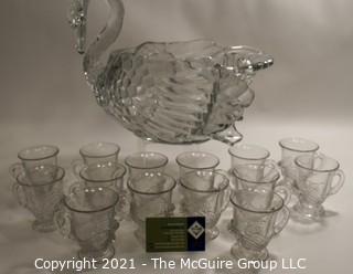 Unmarked Clear Cambridge Glass Swan Punch Bowl with 12 Swan Cups & Ladle. It measures approximately 15 long, 10" tall and 10" wide.  Chip in back tail feather. 