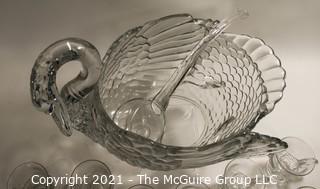 Unmarked Clear Cambridge Glass Swan Punch Bowl with 12 Swan Cups & Ladle. It measures approximately 15 long, 10" tall and 10" wide.  Chip in back tail feather. 