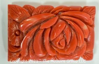 Molded Red Celluloid or Bakelite Clip, Made in Japan. It measures approximately 2" long and 1 1/4" wide.