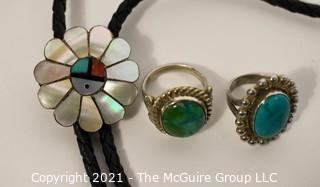 Group of Silver Toned Jewelry Including Bolo Pendant on Leather Cord and Two Rings.