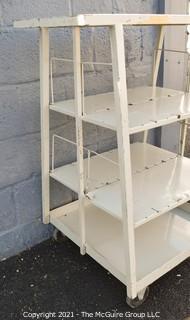 Trapezoidal 4 Shelf Metal Cart with (2) 4" locking swivel castors and 2 fixed; top shelf is 14 x 24" with extending handle; height 40"