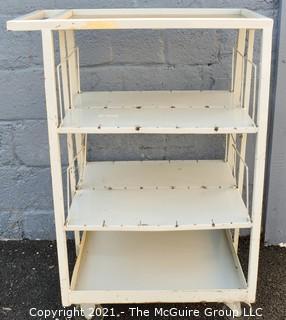 Trapezoidal 4 Shelf Metal Cart with (2) 4" locking swivel castors and 2 fixed; top shelf is 14 x 24" with extending handle; height 40"