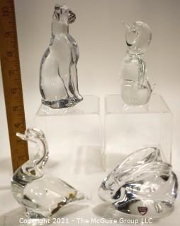 Group of Four (4) Crystal Art Glass Figurines.  Includes Royal Krona Sweden Crystal Art Glass Lead Crystal Penguin Signed By Mats Jonasson, Orrefors Clear Crystal Rabbit Figurine Signed By Artist, Sweden by Granna Glas. Swan & Silvestri Art Glass Clear Sitting Cat . 