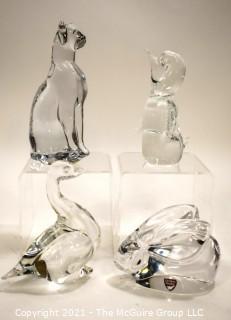 Group of Four (4) Crystal Art Glass Figurines.  Includes Royal Krona Sweden Crystal Art Glass Lead Crystal Penguin Signed By Mats Jonasson, Orrefors Clear Crystal Rabbit Figurine Signed By Artist, Sweden by Granna Glas. Swan & Silvestri Art Glass Clear Sitting Cat . 