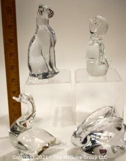 Group of Four (4) Crystal Art Glass Figurines.  Includes Royal Krona Sweden Crystal Art Glass Lead Crystal Penguin Signed By Mats Jonasson, Orrefors Clear Crystal Rabbit Figurine Signed By Artist, Sweden by Granna Glas. Swan & Silvestri Art Glass Clear Sitting Cat . 