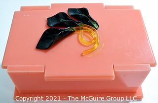 Mid Century Art Deco Salmon Pink Bakelite Trinket Box with Applied Decoration. Measures 7"L.