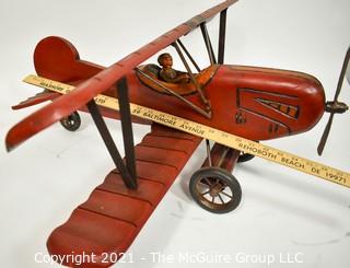 Vintage Red Painted Folk Art Hanging Wooden Biplane with Pilot.  Measures 26"L x  14"T  x 27"W. (TMG Business card placed for size perspective)