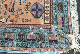 Vintage Hand Knotted Rug with Center Medallion and Border Pattern with Animals on Blue Background.  Measures 107 x 64", with some damage as shown. 