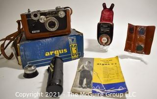 Untested Argus C3 35mm Rangefinder Film Camera with Leather Case in Original Box with Paperwork; Polyco Light Meter and Set of Color Correcting Lenses in Case.  Box is in worn condition. 