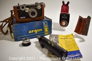 Untested Argus C3 35mm Rangefinder Film Camera with Leather Case in Original Box with Paperwork; Polyco Light Meter and Set of Color Correcting Lenses in Case.  Box is in worn condition. 