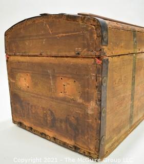 Primitive Antique Wood Camel Back Trunk with Metal Strapping and Red Interior.  Hand Painted Paper Decoration on Sides.  Measures 23"L x 13"T x 13"W.