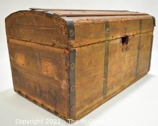 Primitive Antique Wood Camel Back Trunk with Metal Strapping and Red Interior.  Hand Painted Paper Decoration on Sides.  Measures 23"L x 13"T x 13"W.