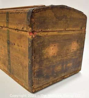 Primitive Antique Wood Camel Back Trunk with Metal Strapping and Red Interior.  Hand Painted Paper Decoration on Sides.  Measures 23"L x 13"T x 13"W.