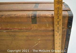 Primitive Antique Wood Camel Back Trunk with Metal Strapping and Red Interior.  Hand Painted Paper Decoration on Sides.  Measures 23"L x 13"T x 13"W.