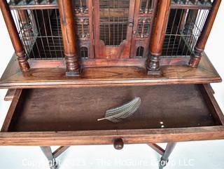 Antique Victorian Monumental Mahogany Continental Carved Sacre Coeur "Cathedral" Bird Cage with Table Base. Modeled with removable central dome, towers at each corner, portico  and hinged doors on each side, refuse drawer, on conforming carved stand.  Measures 70" tall and 26" square. 