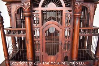 Antique Victorian Monumental Mahogany Continental Carved Sacre Coeur "Cathedral" Bird Cage with Table Base. Modeled with removable central dome, towers at each corner, portico  and hinged doors on each side, refuse drawer, on conforming carved stand.  Measures 70" tall and 26" square. 