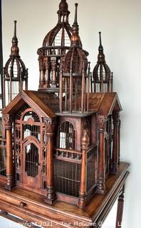 Antique Victorian Monumental Mahogany Continental Carved Sacre Coeur "Cathedral" Bird Cage with Table Base. Modeled with removable central dome, towers at each corner, portico  and hinged doors on each side, refuse drawer, on conforming carved stand.  Measures 70" tall and 26" square. 