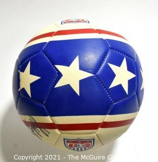 Autographed USA Soccer Ball from the 2008 Summer Olympics.  Signatures include Lauren Cheney Holiday, Stephanie Cox & Amy Rodriguez.  There are additional signatures that are illegible.  