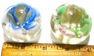 Two (2) Vintage Round Hand Blown Lampwork Glass Paperweights with Blue & Green Flowers. Measures 2" in diameter.