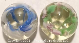 Two (2) Vintage Round Hand Blown Lampwork Glass Paperweights with Blue & Green Flowers. Measures 2" in diameter.