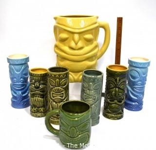 Seven (7) Tiki Mugs Or Tumblers with Pitcher in Blue and Yellow.  Includes two (2) Virginia Distillery Mugs and one (1) Luau Hut cup. Barware. 