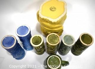 Seven (7) Tiki Mugs Or Tumblers with Pitcher in Blue and Yellow.  Includes two (2) Virginia Distillery Mugs and one (1) Luau Hut cup. Barware. 