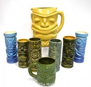 Seven (7) Tiki Mugs Or Tumblers with Pitcher in Blue and Yellow.  Includes two (2) Virginia Distillery Mugs and one (1) Luau Hut cup. Barware. 