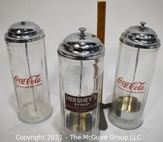 Three (3) Glass & Chrome Soda Fountain Straw Dispensers with Coca Cola & Hershey Logos 