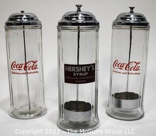 Three (3) Glass & Chrome Soda Fountain Straw Dispensers with Coca Cola & Hershey Logos 