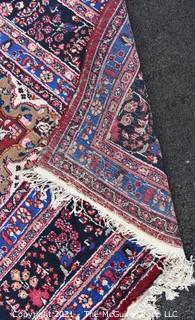 Hand Woven Persian Wool Rug with Medallion Center on Red Ground with Blue Border. Some wear. 
 Measures 115" x 155"