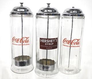 Three (3) Glass & Chrome Soda Fountain Straw Dispensers with Coca Cola & Hershey Logos