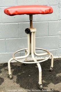 Industrial Adjustible Tubular Steel Rolling Stool with Red Vinyl Seat. 