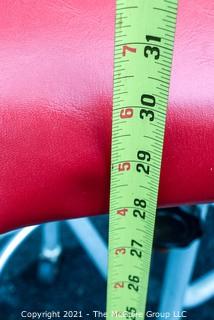 Industrial Adjustible Tubular Steel Rolling Stool with Red Vinyl Seat. 