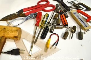 Assortment of tools including wooden mallet, hammer, metal shearing scissors, electric angle grinder and metal screw organizer bin