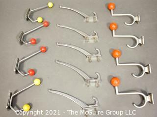 Group of Mid Century Aluminum Wall Hooks with Red and Yellow Wood Knobs.