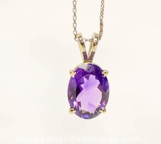 Oval Faceted Amethyst Pendant in 14k Yellow Gold Surround on 18" Chain.