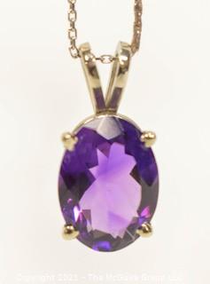 Oval Faceted Amethyst Pendant in 14k Yellow Gold Surround on 18" Chain.