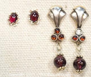 Two Pairs of Sterling Silver and Garnet Pierced Earrings.  One missing small stone. 