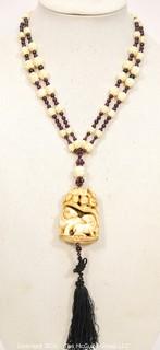 Carved Bone with Garnet Pendant on 32" Tassel Cord Necklace. 