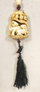 Carved Bone with Garnet Pendant on 32" Tassel Cord Necklace. 