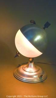 Art Deco Aluminum Globe Hemisphere “Saturn” Swiveling Table Lamp With Brass Arrow. Measures 6"W X 6.5"D X 9.5"T.   Matching lamp to make pair in lot 87SG.