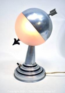 Art Deco Aluminum Globe Hemisphere “Saturn” Swiveling Table Lamp With Brass Arrow Details. Measures: 6"Wide X 6.5" Deep X 9.5" Tall. 