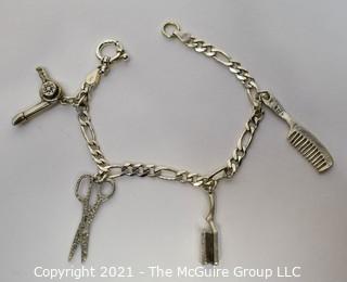 Sterling Silver Link Bracelet with Four Beauty Salon Themed Charms.  Marked Sterling.  Measures 7" long.