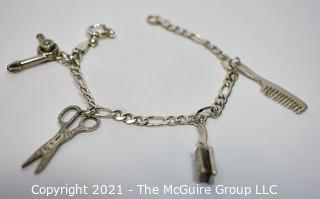 Sterling Silver Link Bracelet with Four Beauty Salon Themed Charms.  Marked Sterling.  Measures 7" long.