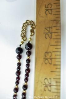 Garnet Bead Necklace with Clasp and Gold Tone Bead Spacers and Chain.  Measures 48" long