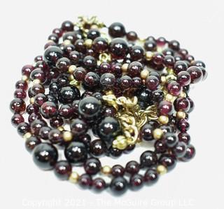 Garnet Bead Necklace with Clasp and Gold Tone Bead Spacers and Chain.  Measures 48" long