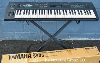 Yamaha SY-35 61-Key Keyboard with AWM/FM Synthesis and Vector Control. Includes folding stand and original box, but needs a common 12V power supply.