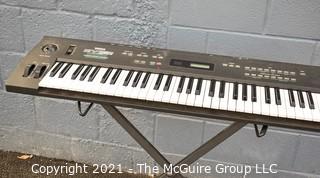 Yamaha SY-35 61-Key Keyboard with AWM/FM Synthesis and Vector Control. Includes folding stand and original box, but needs a common 12V power supply.